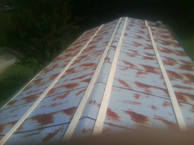 Rusted metal roof panels with new wood purlins before replacement — Storm Damage Roof Repair in Fall Creek by Roofing Brothers